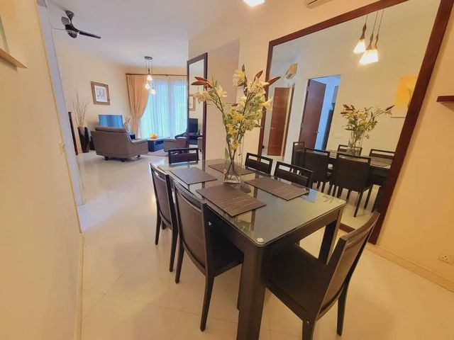 Dining table and chairs beside a large wall mirror