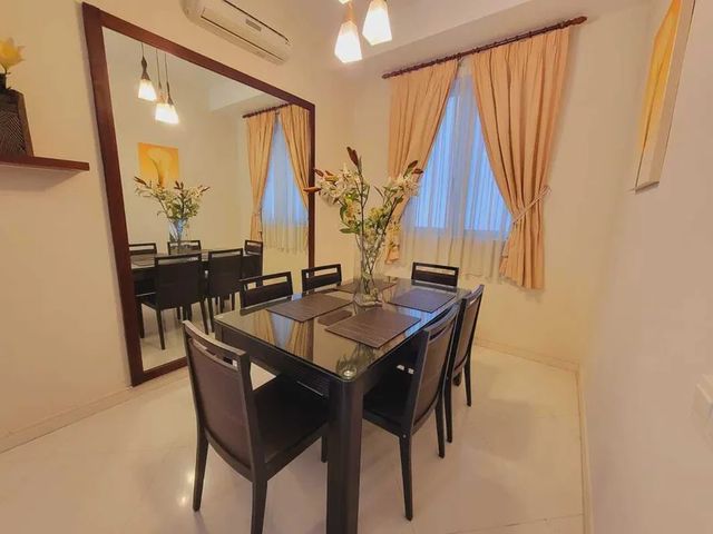 Dining area with wall mirror and pendant lights