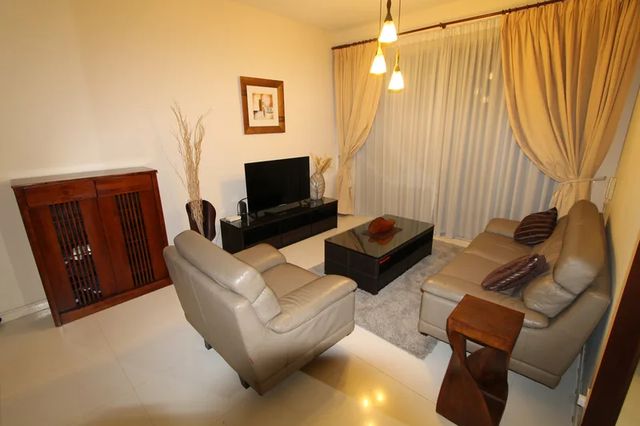 Living room with sofas, television and display cabinet